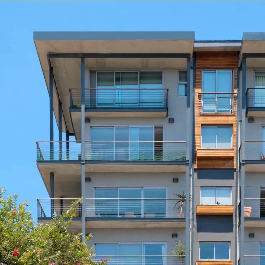 Exterior of the SEVENONT development, with concrete balconies, timber cladding and dark steel frames; photograph from Blok